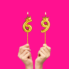 Hands holding number shaped candles - Birthday number 69