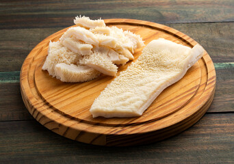 Raw tripe chunks on a wooden board - second beef stomach