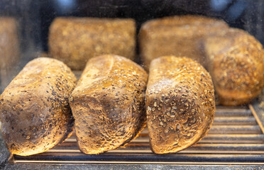 Square bread with mixed seeds in boxes on the counter in the store.