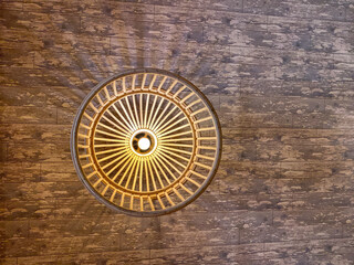 woven bamboo lampshade on the ceiling of a wood-patterned room