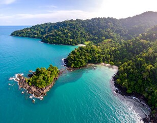 Fototapeta premium Aerial vista of tropical island with dense rainforest and vibrant turquoise waters offers serene