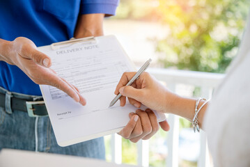 Delivery courier service man deliver package box to woman customer. Mailman shipment holding cardboard package box. Close Up hand receiver signing signature on digital tablet in coronavirus quarantine