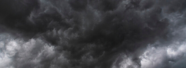 Banner Dramatic dark storm clouds black sky background. Dark thunderstorm clouds rainny season. Panorama Meteorology danger windstorm disasters climate. Dark cloudscape storm cloud with copy space.