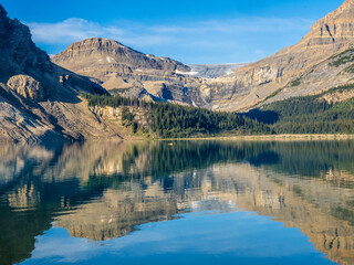  Crystal clear Bow Lake reflecting rugged mountains in Banff National Park