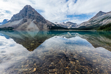  Crystal clear Bow Lake reflecting rugged mountains in Banff National Park