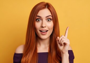 Obraz premium Woman With Long Red Hair And Wide Eyes Points Her Finger Up, Having A Sudden Brilliant Idea Against A Vibrant Yellow Background, Eureka Moment, Excitement, Innovative Thinking