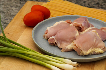 Vegetables, pasta, and chicken thigh ingredients for cooking