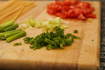 Uncooked Pasta and Fresh Vegetables on Wooden Cutting Board for Meal Prep