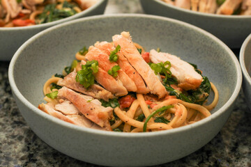 Closeup of Bowl of Creamy Tuscan Linguine Pasta with Chicken Thighs