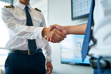 Two pilots in uniform shaking hands in agreement
