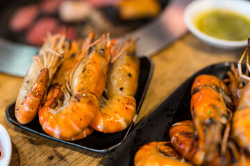 Fresh river prawns grilled being burned to turn orange on black tray