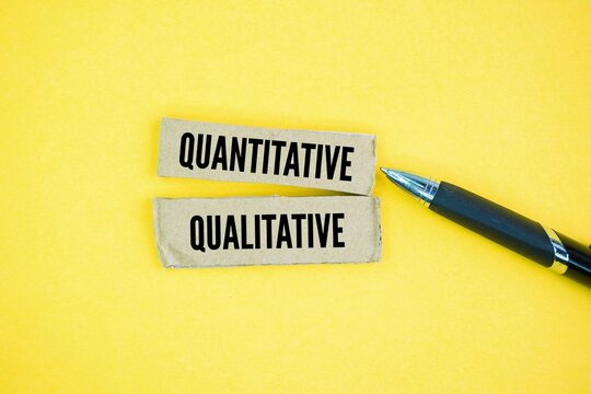 Pen and paper with the words quantitative and qualitative. Quantitative data deals with numbers and statistics, while qualitative data focuses on descriptions and meanings.