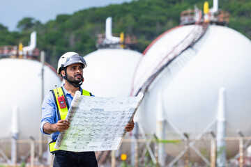 Industrial engineer inspecting petrochemical facility construction blueprint at gas storage plant...