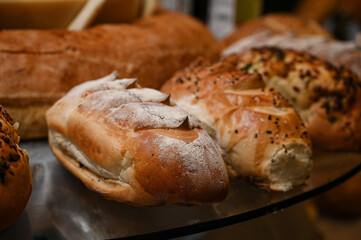 fresh bread assortment with melted cheese fondue, bakery display with cheese wheel, artisan bread and cheese platter,bread with sesame seeds, assorted breads, bread display
