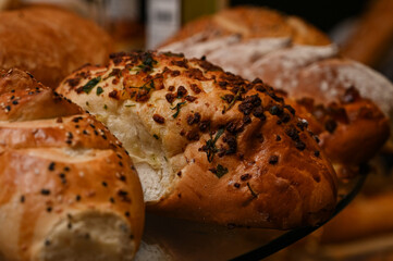  fresh bread assortment with melted cheese fondue, bakery display with cheese wheel, artisan bread and cheese platter,bread with sesame seeds, assorted breads, bread display, sweet bread