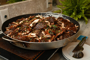 mushroom and meat dish, buffet food catering, large pan with gourmet meal, delicious beef and...