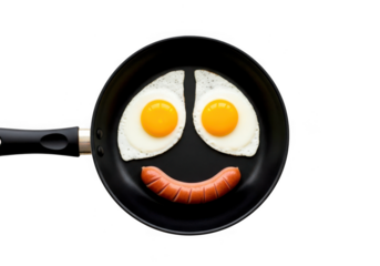 Funny breakfast face made from fried eggs and sausage in a frying pan isolated on transparent background