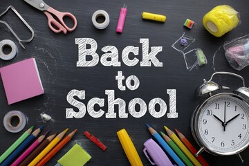 School supplies arranged on a chalkboard, with the words "Back to School" written in chalk