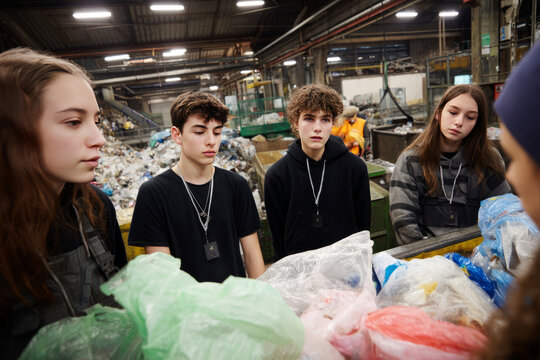 Morning in a recycling center filled with bags and bins Teens are learning how to separate waste materials properly 
