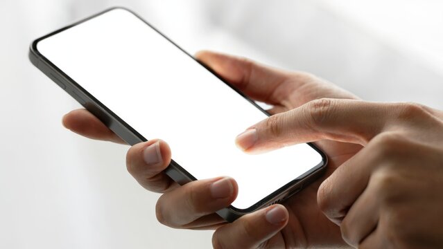 Close-up of hands holding and interacting with a modern smartphone, blank screen ready for content.