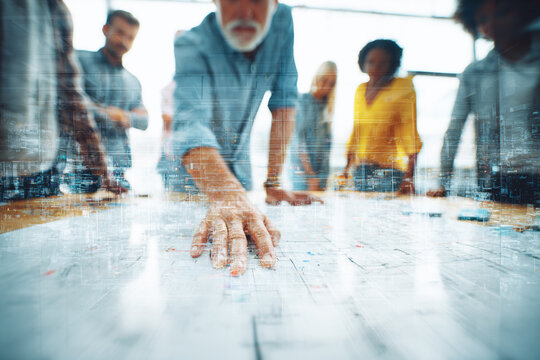 Business team collaborating over a large map with double exposure of city skyline teamwork collaboration