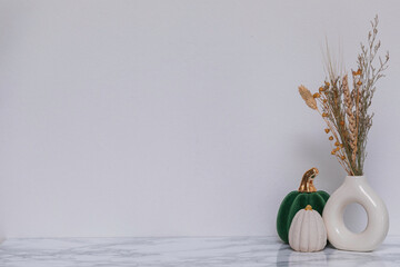 Contemporary fall arrangement featuring circular ceramic vases, dried grass, and a touch of luxury...