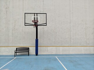 Minimalist Outdoor Basketball Court with Hoop and Bench. A minimalist outdoor basketball court...
