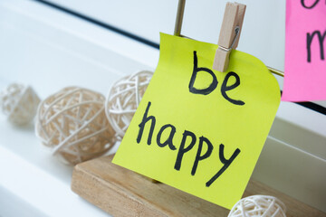 BE HAPPY wellbeing goal on Action board new year's resolutions on colorful sticky notes. Making...