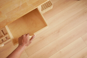 Hand opening drawer in a wooden cabinet at home