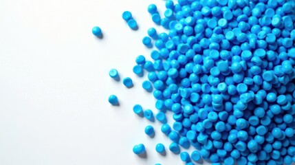 A vibrant scattering of small, bright blue plastic pellets against a clean white background, ideal for illustrating concepts of manufacturing, polymer science, or product design.
