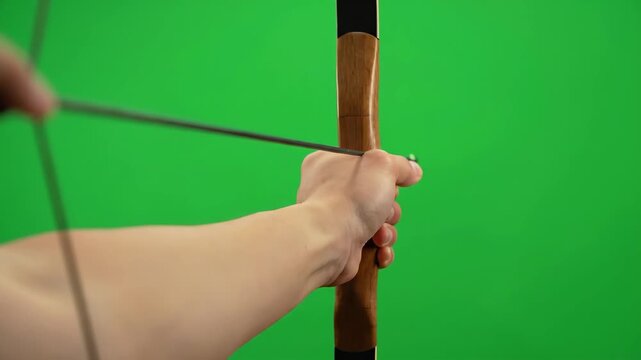 Archery Aim - Green Screen - Close-up shot of a hand drawing a bowstring back, aiming an arrow against a bright green screen background. The video is perfect for compositing and visual effects.