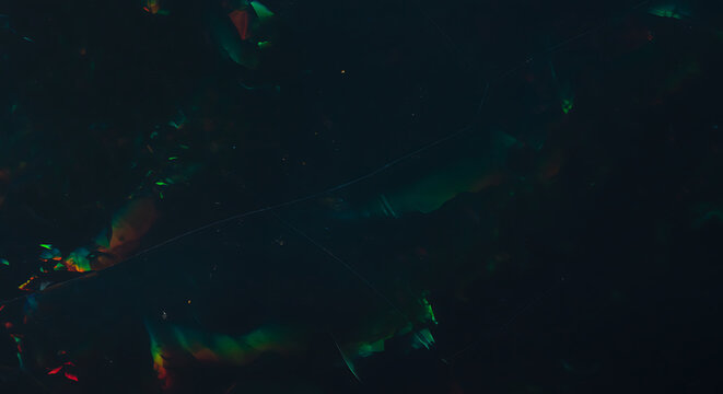 Stunning black opal gemstone with vibrant flashes of green, red, and blue color play for jewelry design