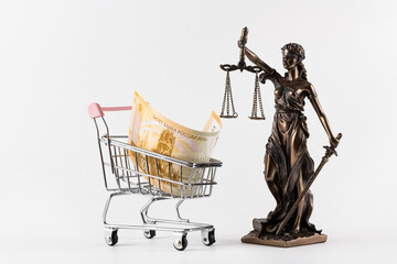 A 100 Russian ruble banknote in a miniature shopping cart and a figure of Themis