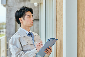 建物を確認する作業服姿の男性