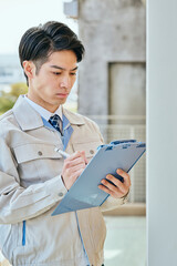 建物を確認する作業服姿の男性