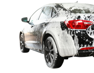 A sleek black car covered in foam, showcasing its shiny exterior and modern design.