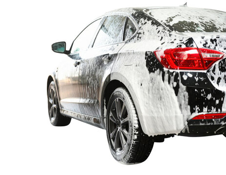 A sleek black car covered in foam, showcasing its shiny exterior and modern design.