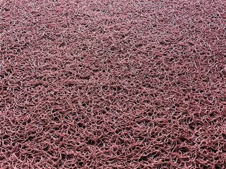 Red rubber foot mat texture. Patterned doormat rug background. Rubber doormat.