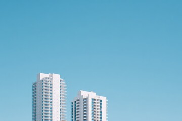 Tall modern buildings rise against clear blue sky creating strik