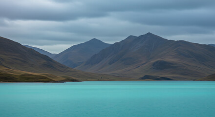 Spectacular mountain landscape with turquoise lake under cloudy sky