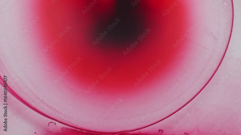 Poster red color ink spreading forming shimmering galaxy. macro view.