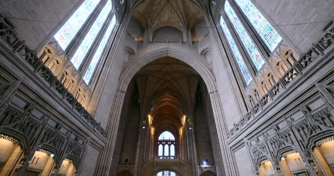 Wide angle view of the nave and altar inside Liverpool Cathedral, highlighting its gothic revival architecture and colorful stained glass
