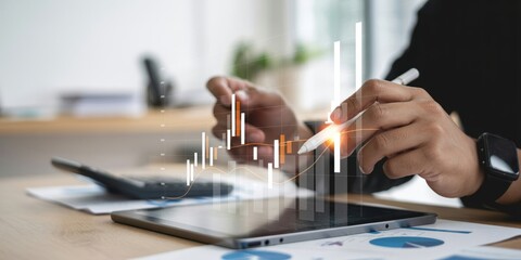 Business Analysis - A man's hands using a digital pen to interact with a tablet, with a financial graph and calculator on the desk