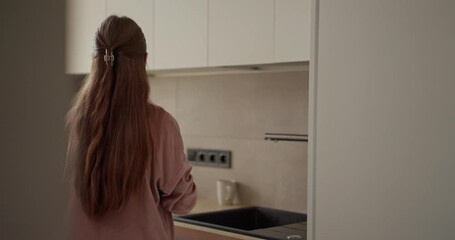 Teenage girl take cold milk out of the refrigerator and starts preparing breakfast in the kitchen in the morning. Teenage girl and breakfast in the morning in the kitchen