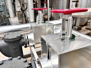 Industrial stainless steel pipeline system with red-handled gate valves. Used in HVAC, steam, and...