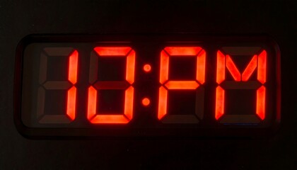 Glowing Red LED Clock Displaying PM in Dark Room