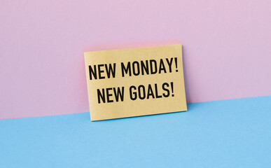 A yellow piece of paper with the words New Monday New Goals written on it