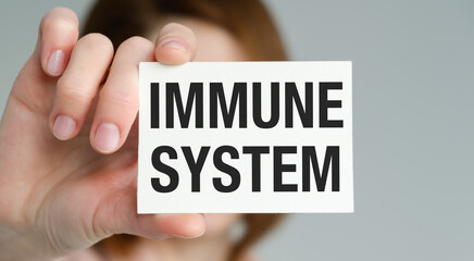 A person is holding a white card that says Immune System