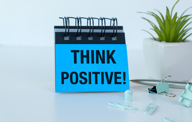 A blue notebook with the words Think Positive written on it