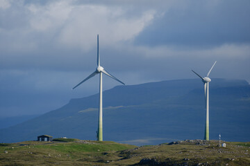 Wind turbines harnessing energy against the dramatic landscape of the Faroe Islands